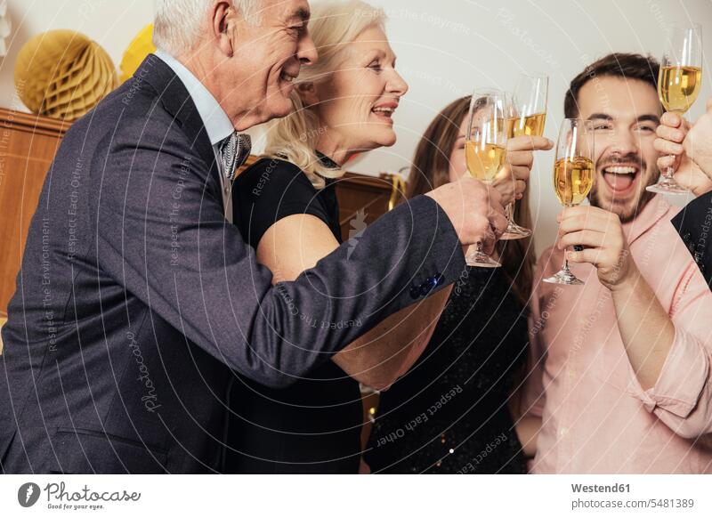 Friends celebrating New Year's Eve together, drinking champagne friendship festive young women young woman senior women elder women elder woman old senior woman