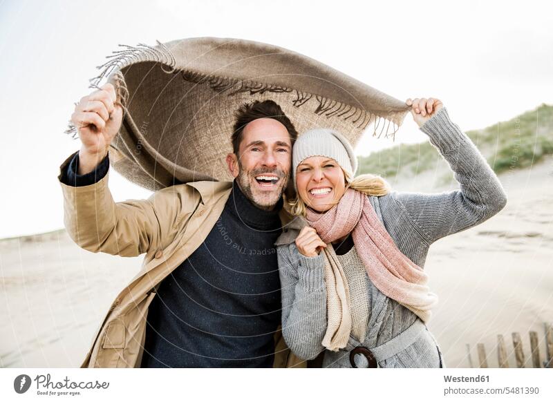 Portrait of happy couple on beach laughing Laughter beaches twosomes partnership couples positive Emotion Feeling Feelings Sentiments Emotions emotional people