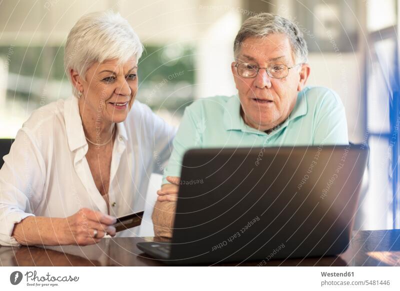 Senior couple shopping online with credit card senior men senior man elder man elder men senior citizen debit card twosomes partnership couples laptop