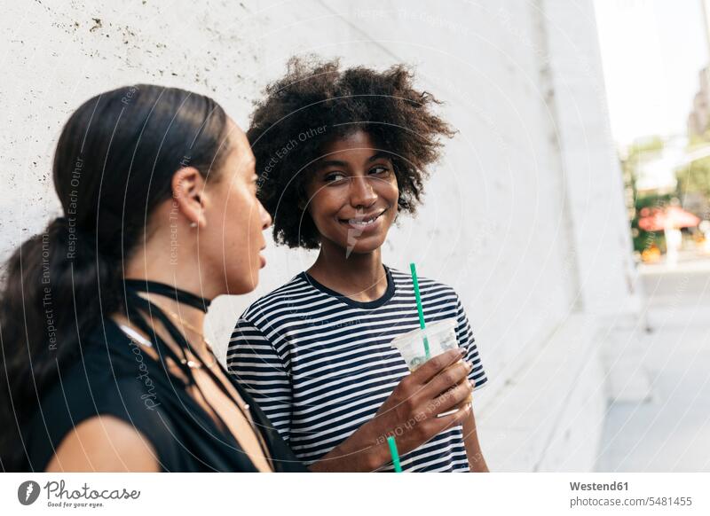 Portrait of smiling woman with drink listening to her friend females women portrait portraits Adults grown-ups grownups adult people persons human being humans