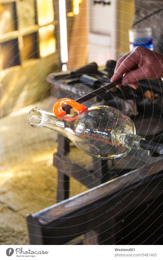 Man manufacturing a glass base in a glass factory men males shaping Forming glass-blower glassware occupation profession professional occupation jobs