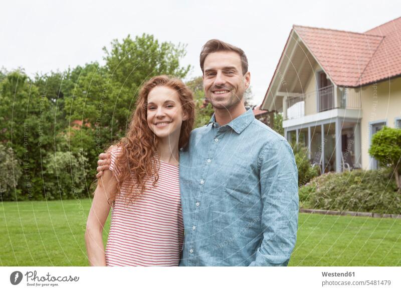 Portrait of smiling couple in garden smile twosomes partnership couples people persons human being humans human beings house houses gardens domestic garden