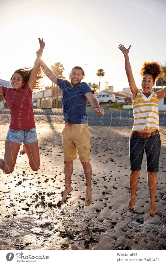Happy friends jumping in the air on the beach beaches friendship Leaping Joy enjoyment pleasure Pleasant delight excitement enthusiastic enthusiasm excited