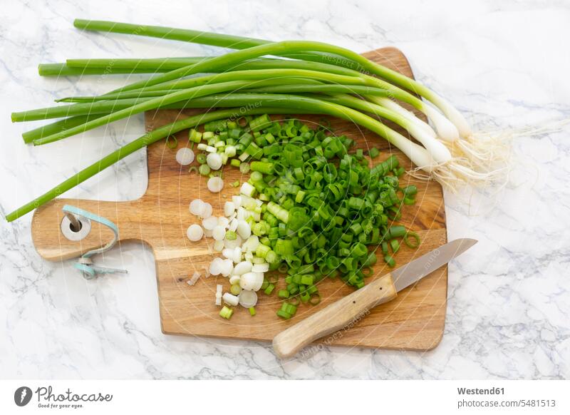 Chopped and whole spring onions on wooden board nobody Kitchen Knife Kitchen Knives chopped cut green onion wooden boards wooden panel wooden panels uncooked