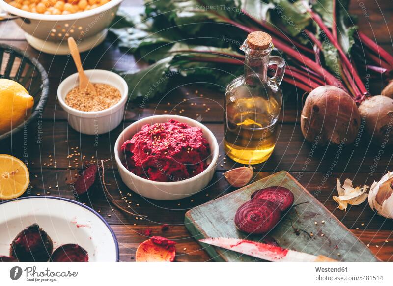 Bowl of Beetroot Hummus and ingredients on wood garlic clove Garlic Cloves clove of garlic wooden board wooden boards wooden panel wooden panels mashed puréed