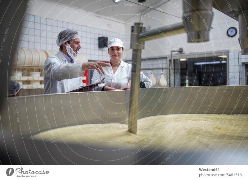 Cheese factory workers controlling curdling process skilled worker skilled workers Mixer Stirrer Whisking Machine cheese factory cheese dairy working At Work