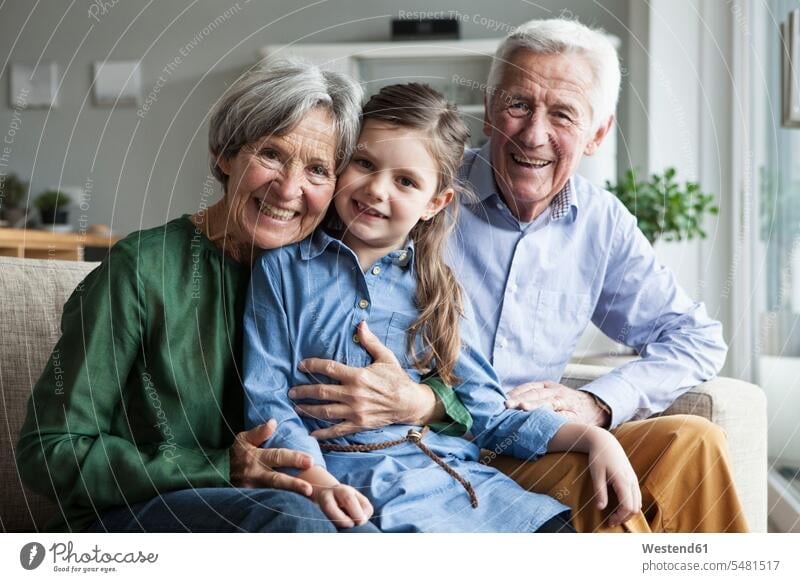 Family portrait of grandparents and their granddaughter at home Germany girl females girls childhood toothy smile big smile open smile laughing head to head