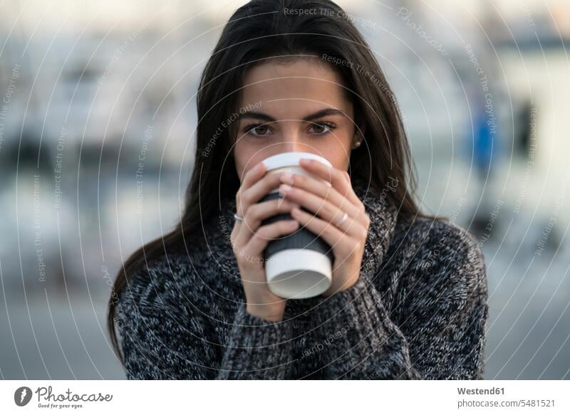 Woman drinking from takeway cup holding Coffee woman females women Drink beverages Drinks Beverage food and drink Nutrition Alimentation Food and Drinks Adults