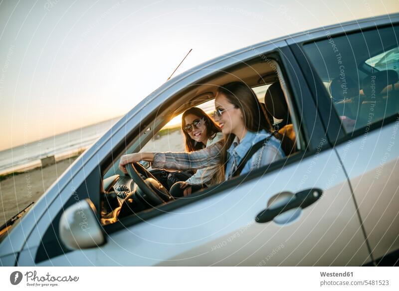 Two young women traveling in a car automobile Auto cars motorcars Automobiles female friends motor vehicle road vehicle road vehicles motor vehicles mate