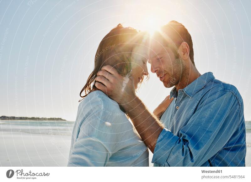 Couple head to head on the beach at backlight couple twosomes partnership couples beaches people persons human being humans human beings Sea ocean water
