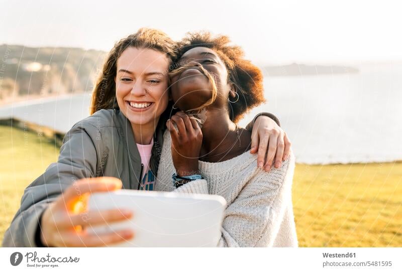 Two happy best friends making a selfie at the coast female friends woman females women happiness mobile phone mobiles mobile phones Cellphone cell phone