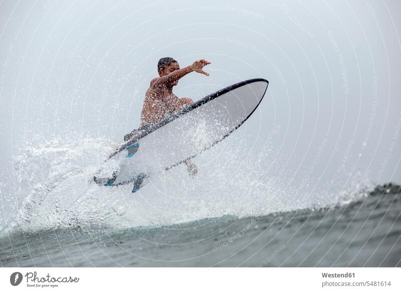 Indonesia, Java, man surfing surf ride surf riding Surfboarding wave waves surfboard surfboards surfer surfers Sea ocean water sports Water Sport aquatics
