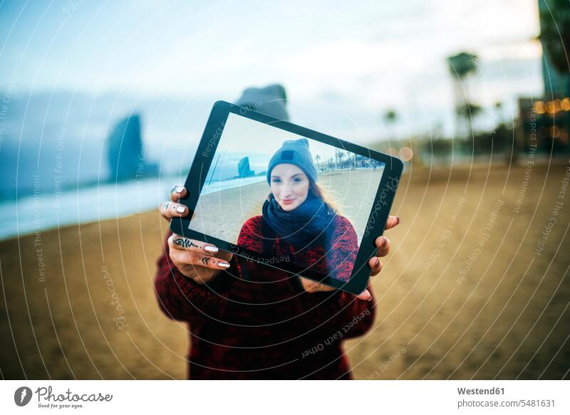 Young woman on the beach in winter taking a selfie with a tablet photograph photographs photos digitizer Tablet Computer Tablet PC Tablet Computers iPad