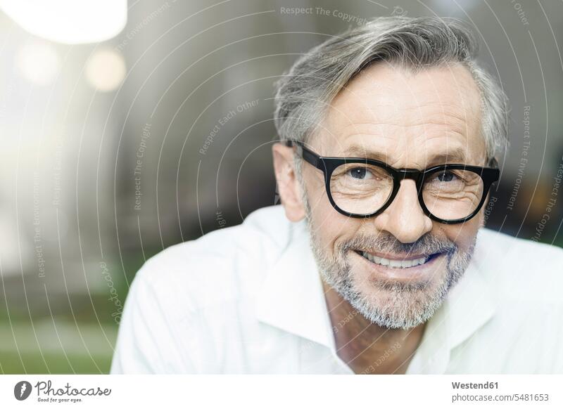 Portrait of smiling man with grey hair and beard wearing spectacles men males smile portrait portraits Adults grown-ups grownups adult people persons