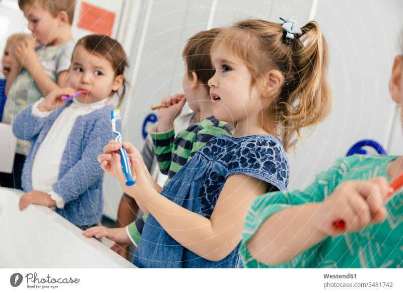Children brushing their teeth in bathroom of a kindergarten nursery school brushing teeth child children kid kids pedagogics people persons human being humans