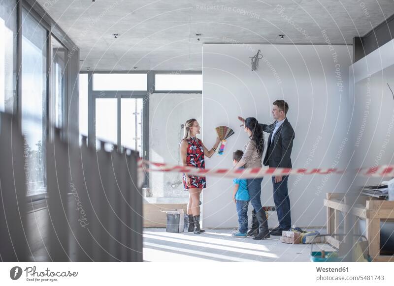 Woman with color sample and family in building shell families construction site Building Site sites Building Sites construction sites people persons human being
