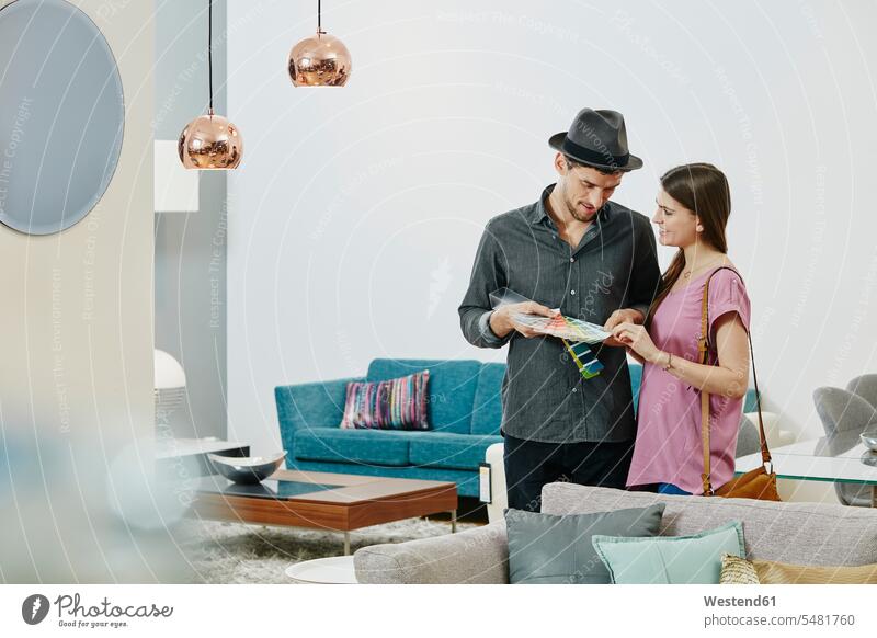 Couple in furniture store looking at color samples choosing select choose selecting hip trendy Furniture Furnitures modern contemporary couple twosomes
