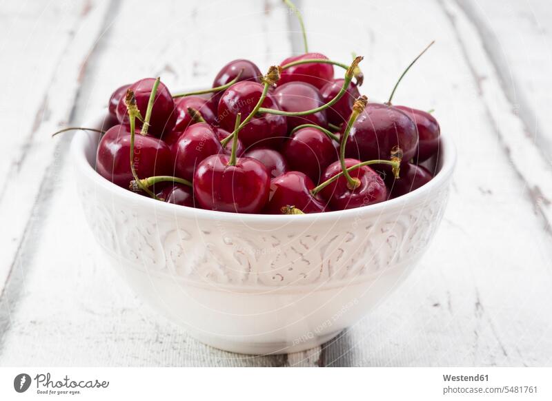 Bowl of cherries on white wood Bowls studio shot studio shots studio photograph studio photographs healthy eating nutrition wooden many plenty sweet Sugary