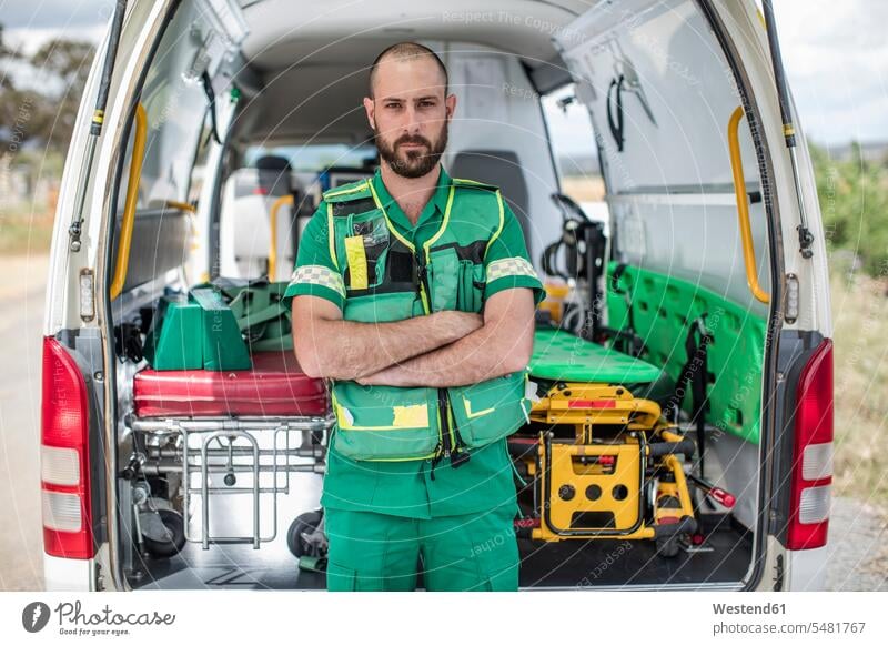 Paramedic standing with arms crossed in front of ambulance paramedic paramedics ambulance vehicles healthcare and medicine medical Healthcare And Medicines