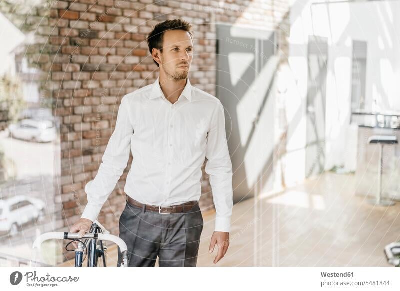 Businessman with bicycle in office bikes bicycles Business man Businessmen Business men business people businesspeople business world business life offices
