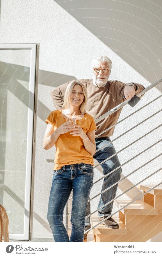 Portrait of smiling couple at home twosomes partnership couples smile portrait portraits stairs stairway people persons human being humans human beings