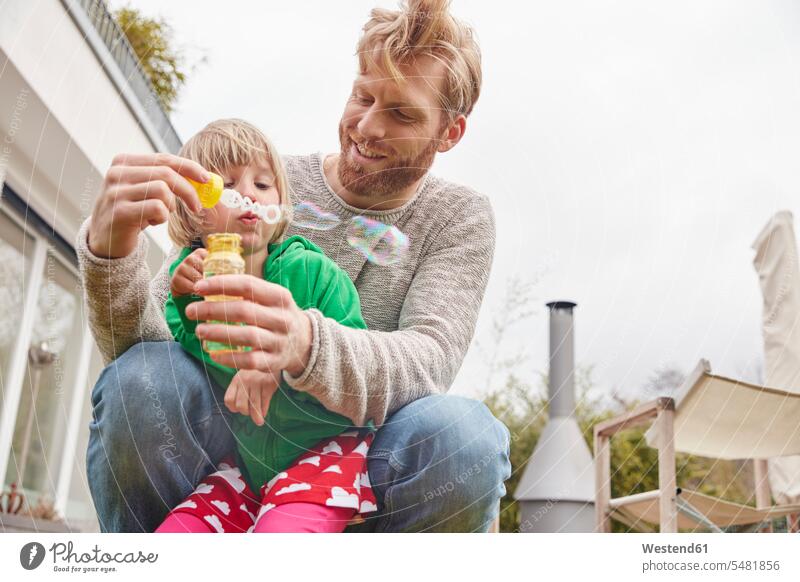 Father and daughter blowing soap bubbles confidence confident togetherness recreation relaxing Recreational childhood fatherhood paternity one parent