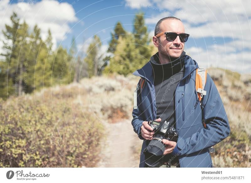 USA, Wyoming, man with camera at Grand Teton National Park photographer photographers men males cameras Adults grown-ups grownups adult people persons