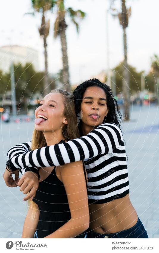 Two playful young women on square female friends woman females mate friendship Adults grown-ups grownups adult people persons human being humans human beings