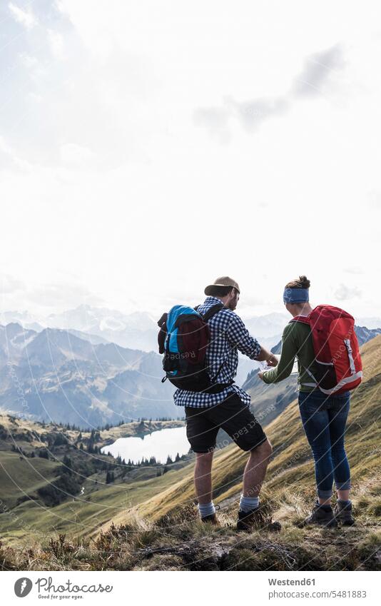 Germany, Bavaria, Oberstdorf, two hikers with map in alpine scenery maps couple twosomes partnership couples hiking standing mountain range mountains