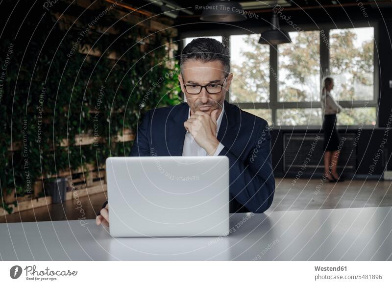 Businessman using laptop in green office Business man Businessmen Business men Laptop Computers laptops notebook business people businesspeople business world