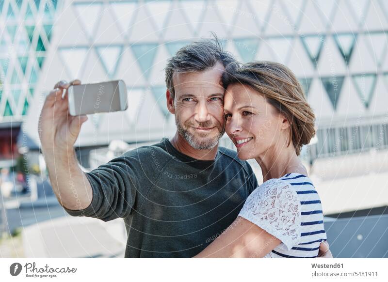 Happy mature couple taking a selfie outdoors Love loving smiling smile twosomes partnership couples positive Emotion Feeling Feelings Sentiments Emotions