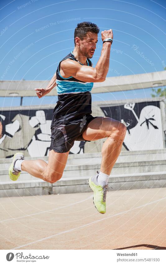 Fit man exercising outdoors athlete Sportspeople Sportsman Sportsperson athletes Sportsmen exercise training practising jumping Leaping sport sports jumps