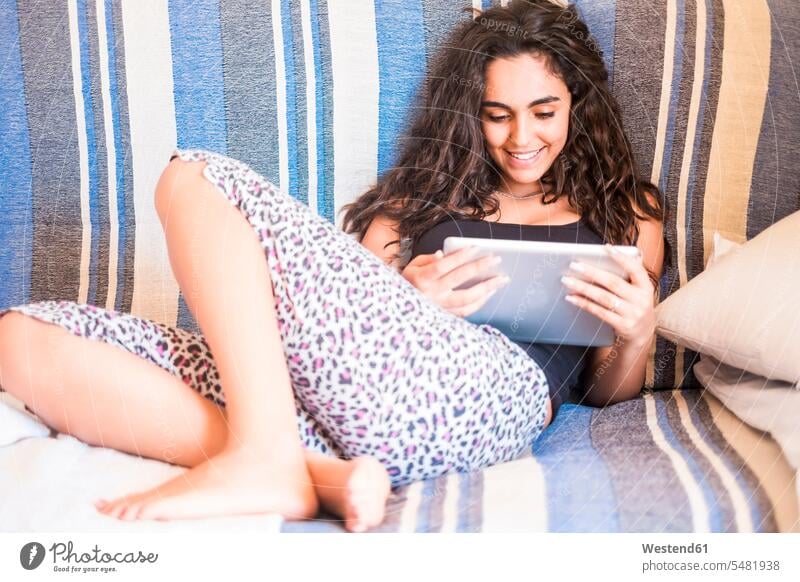 Teenage girl sitting on the couch looking at tablet digitizer Tablet Computer Tablet PC Tablet Computers iPad Digital Tablet digital tablets Teenage Girls