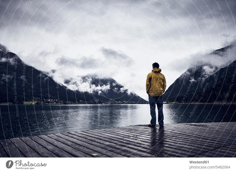 Austria, Tyrol, Lake Achen, man standing on boardwalk men males dark weather sulky weather boardwalks leisure free time leisure time Achensee Adults grown-ups