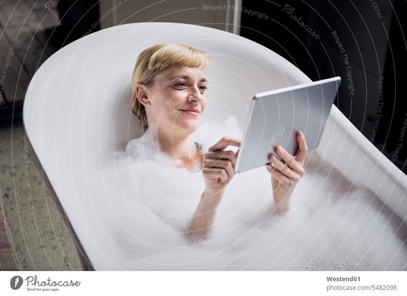 Portrait of relaxed woman taking bubble bath while using tablet females women bathtub tubs bathtubs bath tubs digitizer Tablet Computer Tablet PC