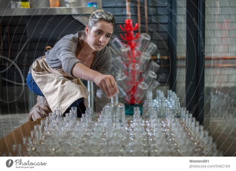 Young woman sorting glass bottles females women Bottle Bottles Adults grown-ups grownups adult people persons human being humans human beings working At Work