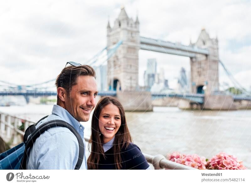 UK, London, smiling couple with the Tower Bridge in the background smile twosomes partnership couples England United Kingdom Great Britain people persons