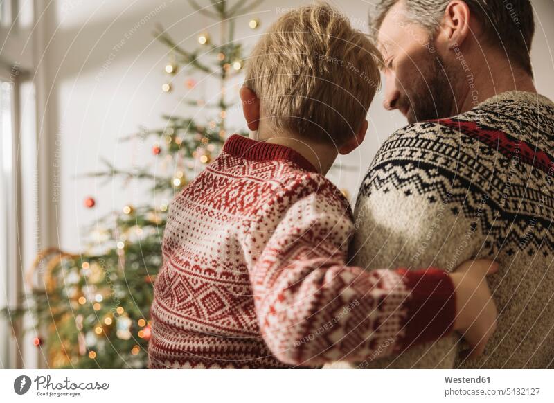 Father and little son looking at Christmas tree caucasian caucasian ethnicity caucasian appearance european Security Secure Love loving bonding community