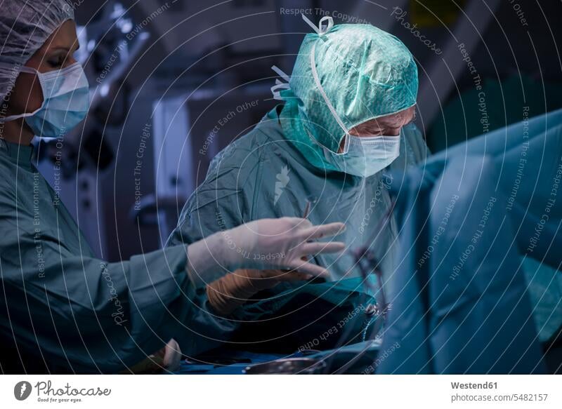 Neurosurgeon with nurse closing operation wound surgery surgeries operating doctor physicians doctors nurses treatment Medical Treatment treatments