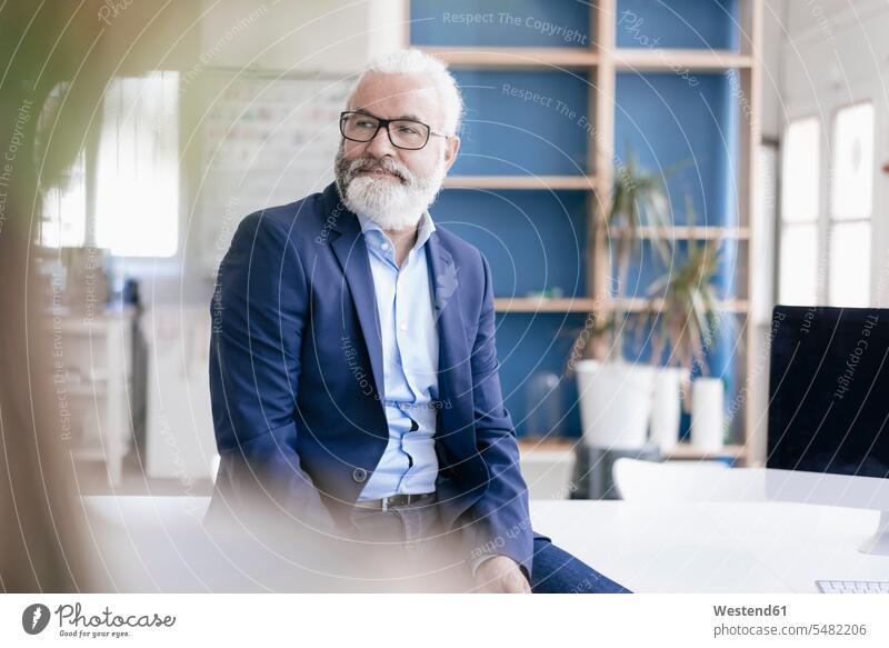 Confident mature man with beard and glasses in office men males Adults grown-ups grownups adult people persons human being humans human beings Businessman