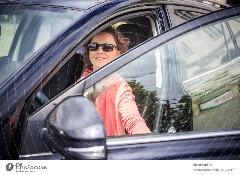 Portrait of woman wearing sunglasses getting on her car females women Adults grown-ups grownups adult people persons human being humans human beings smiling