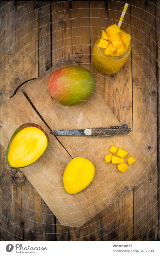 Glass of mango smoothie and whole and sliced mango food and drink Nutrition Alimentation Food and Drinks Mango Mangoes Mango Fruits Mangos wooden wooden board