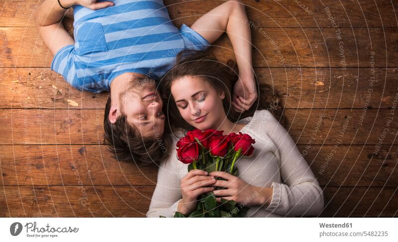 Young couple in love lying on wooden floor leisure free time leisure time lovers waist up Waist-Up upper body upper part shot upside down head first headfirst