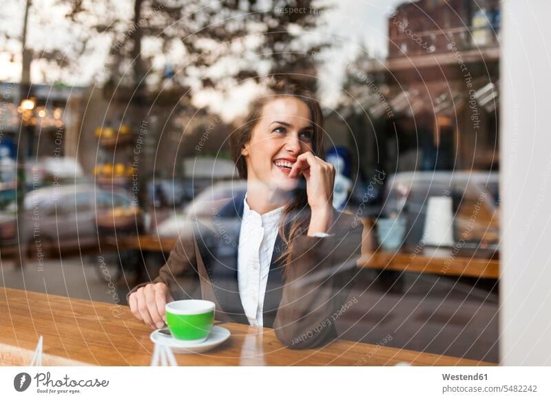 Smiling young woman in a cafe Coffee window windows females women smiling smile Drink beverages Drinks Beverage food and drink Nutrition Alimentation