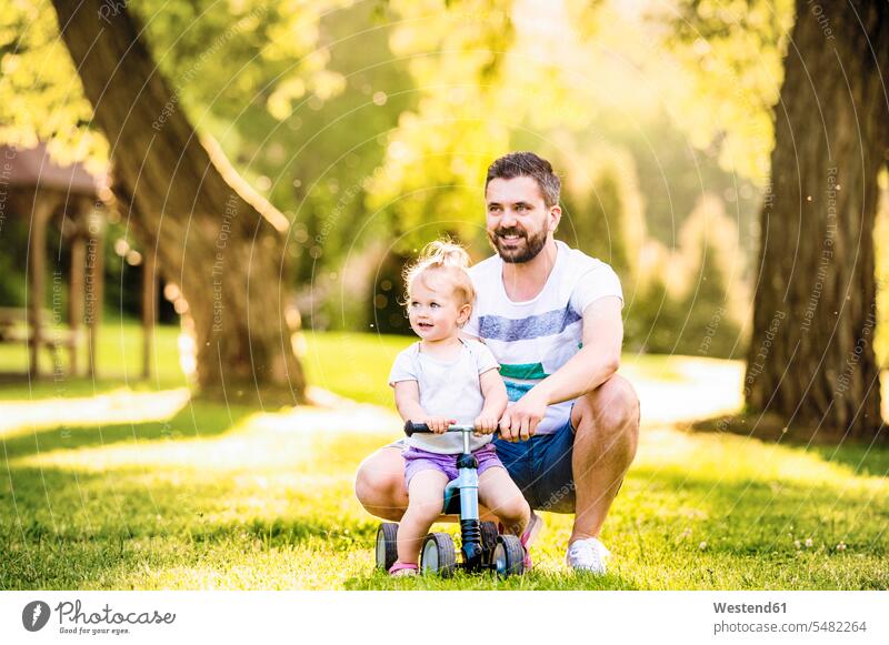Father and his little daughter with toy car in a park smiling smile cars toy cars father fathers daddy dads papa daughters toys parents family families people