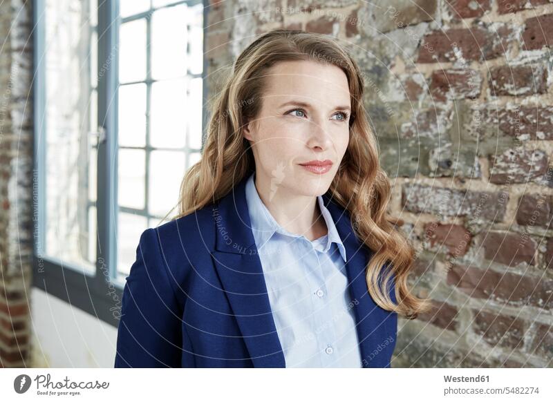 Portrait of businesswoman at brick wall businesswomen business woman business women brick walls business people businesspeople business world business life