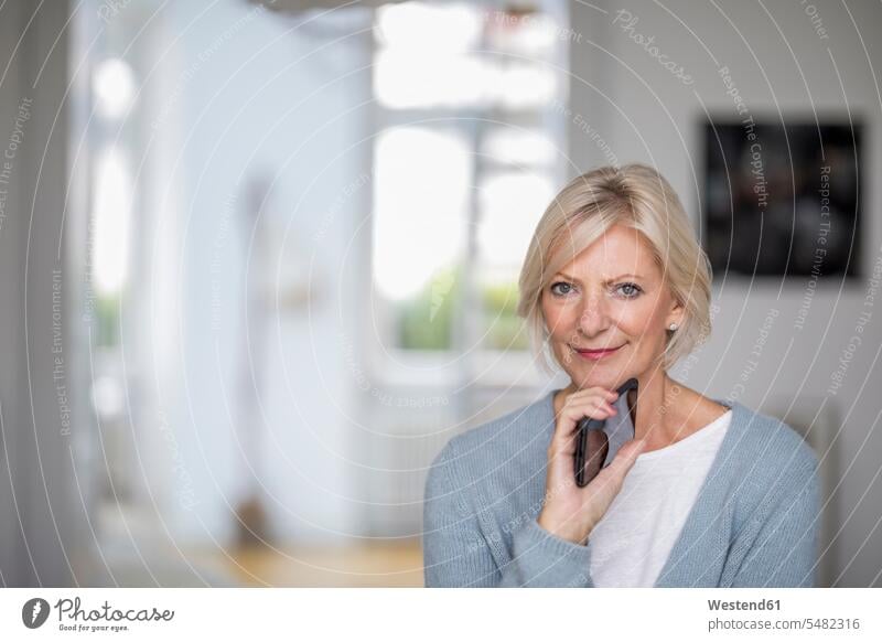 Portrait of senior woman with cell phone at home portrait portraits senior women elder women elder woman old senior adults females Adults grown-ups grownups