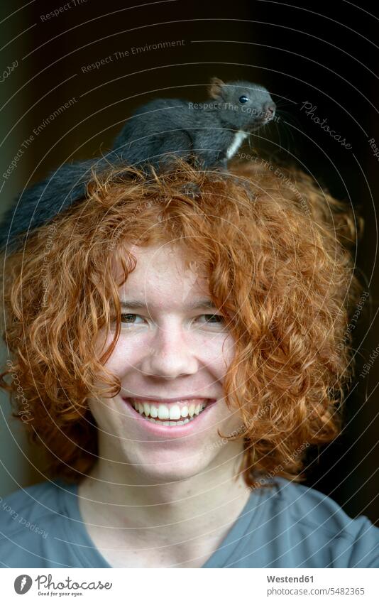 Portrait of happy redheaded teenage boy with squirrel on his head red hair red hairs red-haired portrait portraits red squirrel Sciurus vulgaris