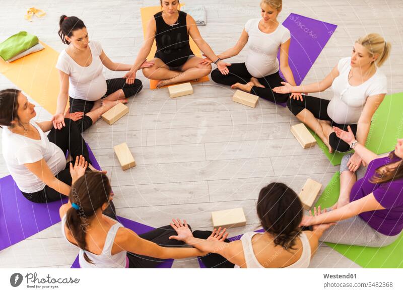 Prenatal yoga class sitting together in circle pregnant Pregnant Woman group of people Group groups of people Seated woman females women persons human being