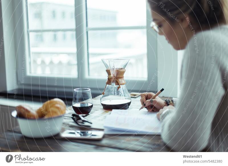 Young woman working at table at home Coffee females women Drink beverages Drinks Beverage food and drink Nutrition Alimentation Food and Drinks Adults grown-ups
